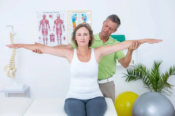 Doctor stretching his patients arms — Stock Photo, Image