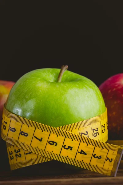 Green and red apples with measuring tape — Stock Photo, Image
