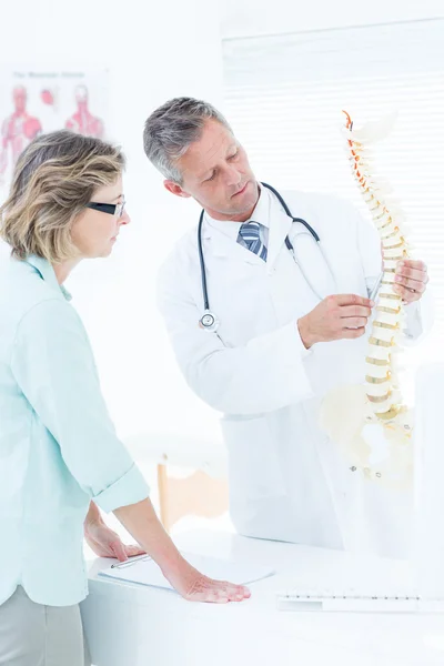 Arzt spricht mit Patient und zeigt Wirbelsäule — Stockfoto