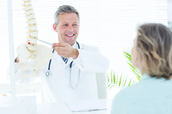 Arzt zeigt seinem Patienten ein Wirbelsäulenmodell — Stockfoto