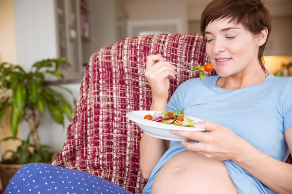 Pregnant woman eating a salad Stock Image