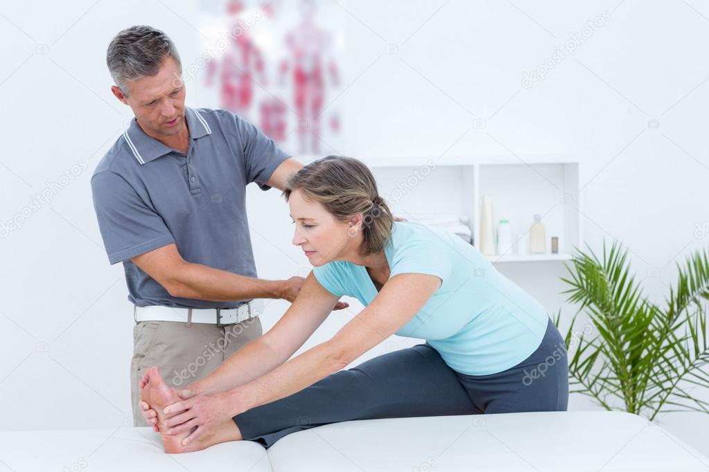 Physiotherapist helping his patient stretching — Stock Photo