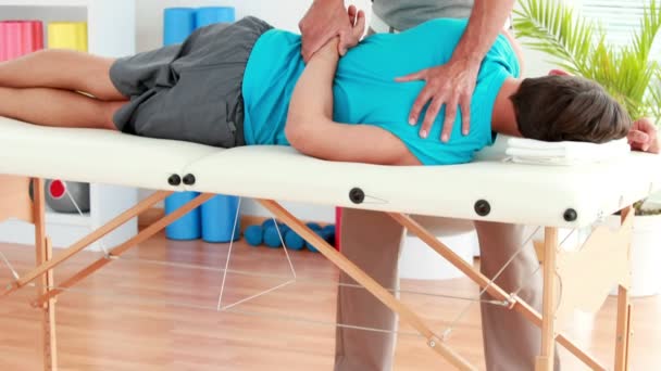 Физиотерапевт делает пациенту спортивный массаж — стоковое видео