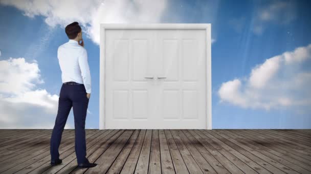 Дверь открывается в голубое небо, за которым наблюдает бизнесмен — стоковое видео
