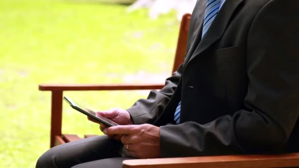 Businessman using tablet in the park — Stock Video