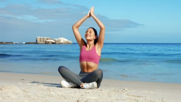 Fit woman meditating on the beach — Stock Video
