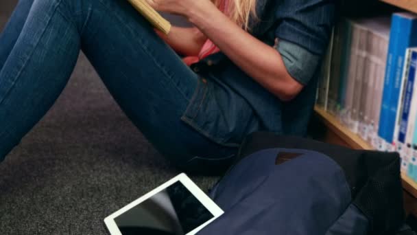 Gelukkig blonde student lezen van een boek — Stockvideo