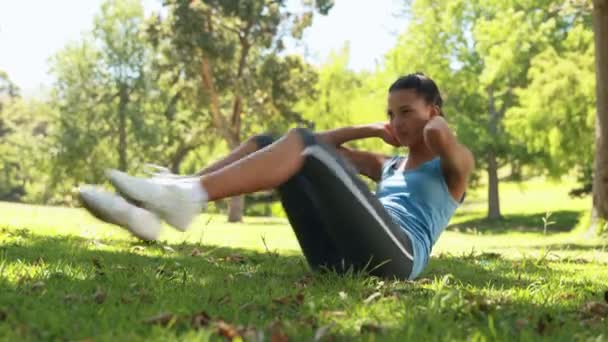 Fit vrouw doen sit ups in het park — Stockvideo