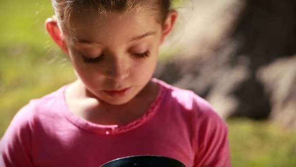 Happy little girl looking at butterfly — Stock Video