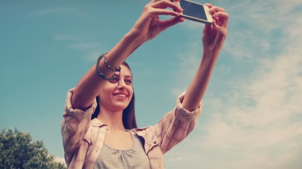 Morena bonita tirando uma selfie no parque — Vídeo de Stock