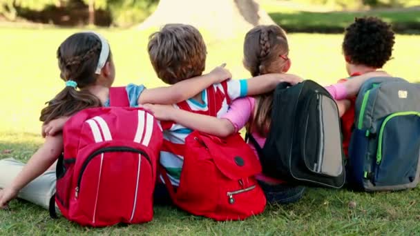 Schulkinder sitzen auf Gras — Stockvideo