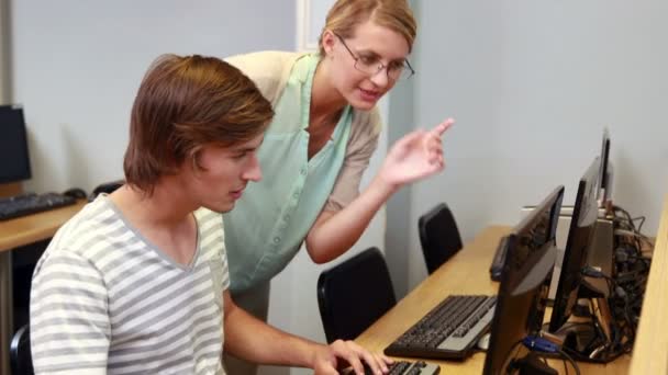 Profesor ayudando a estudiante con la computadora — Vídeo de stock