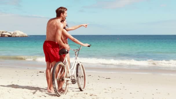 Pareja despreocupada en un paseo en bicicleta por la playa — Vídeo de stock