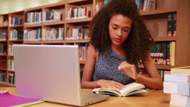 Estudiante serio estudiando y sonriendo a la cámara — Vídeo de stock