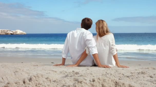 Casal feliz sentado na praia — Vídeo de Stock