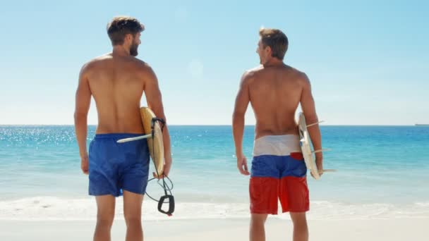 Счастливые друзья-серферы на пляже — стоковое видео