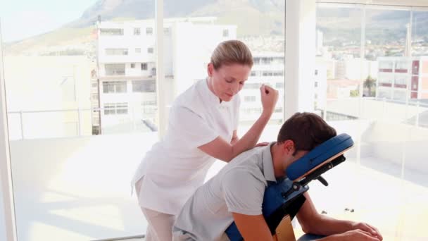 Mujer terapeuta masaje hombre sentado en silla de masaje — Vídeos de Stock