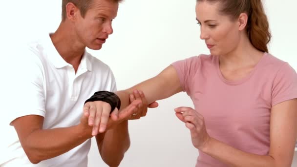 Физиотерапевт двигает руку пациенту — стоковое видео