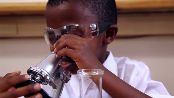 Pupil looking through microscope — Stock Video