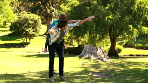 Vader en zoon spelen in een park — Stockvideo