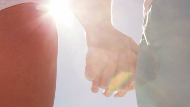 Ζευγάρι στέκεται χέρι-χέρι στην παραλία — Αρχείο Βίντεο