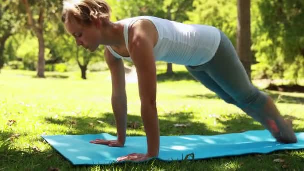 Vältränad kvinna gör yoga i parken — Stockvideo