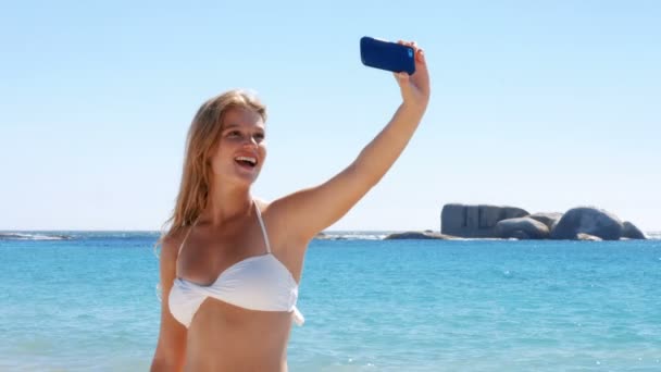 Красивая блондинка делает селфи на пляже — стоковое видео