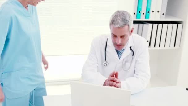 Concentrated doctors looking at laptop — Stock Video