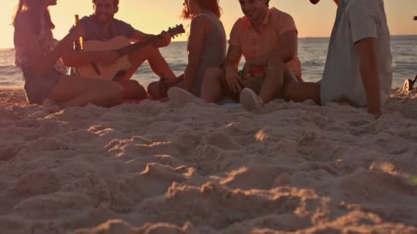 Vrienden zitten op het strand en het spelen van gitaar — Stockvideo
