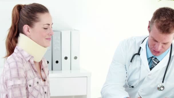 Doctor speaking with patient in neck brace — Stock Video