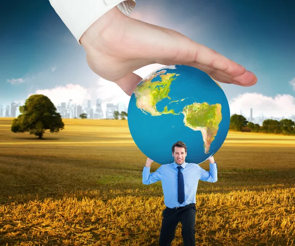 Hand holding earth and businessman — Stockfoto