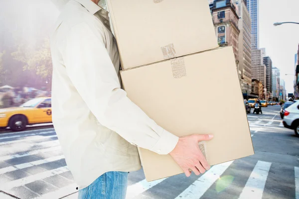 Samengestelde afbeelding van levering man uitvoering van kartonnen dozen — Stockfoto