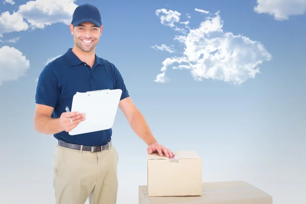 Composite image of happy delivery man with cardboard boxes and c — Stock Photo, Image