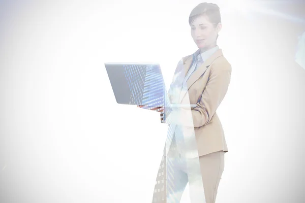 Composite image of confident businesswoman holding laptop — Stock Photo, Image