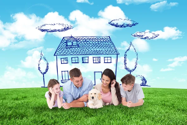 Composite image of family looking at puppy while lying — Stock Photo, Image