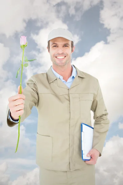 Entrega homem com prancheta oferecendo rosa — Fotografia de Stock