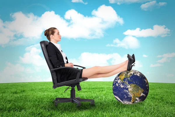 Businesswoman sitting on swivel chair with feet up — Stock Photo, Image