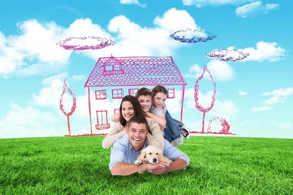 Composite image of happy family lying on top of each other with — Stock Photo, Image