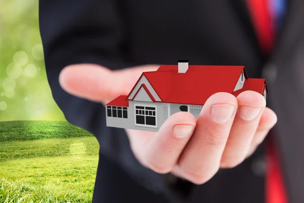 Empresário apresentando com sua casa de mão — Fotografia de Stock