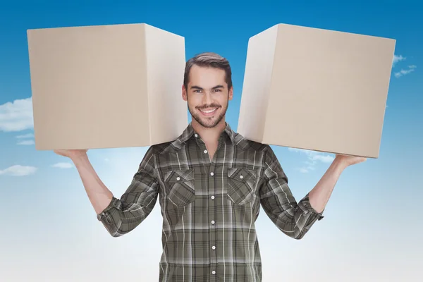 Imagen compuesta de hombre feliz sosteniendo cajas —  Fotos de Stock