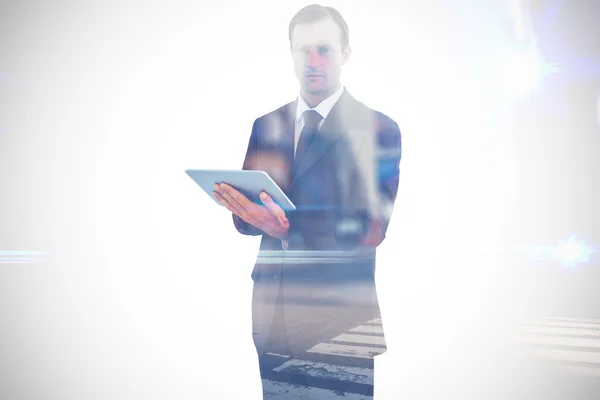 Serious charismatic businessman holding a tablet — Stock Photo, Image