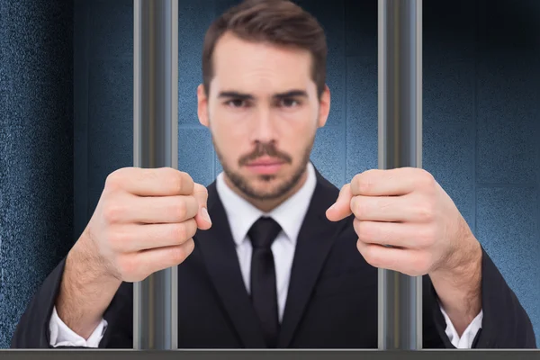 Composite image of businessman in prison — Stockfoto