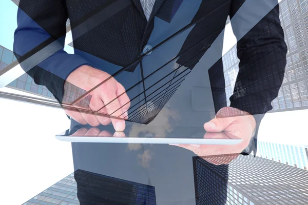 Composite image of businessman using his tablet pc — Stock Photo, Image