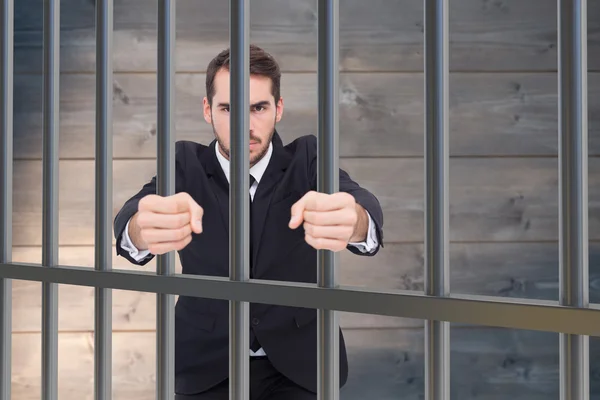 Composite image of businessman in prison — Stock Photo, Image