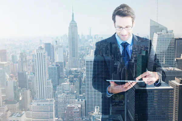 Businessman standing while using a tablet pc — Stock Photo, Image