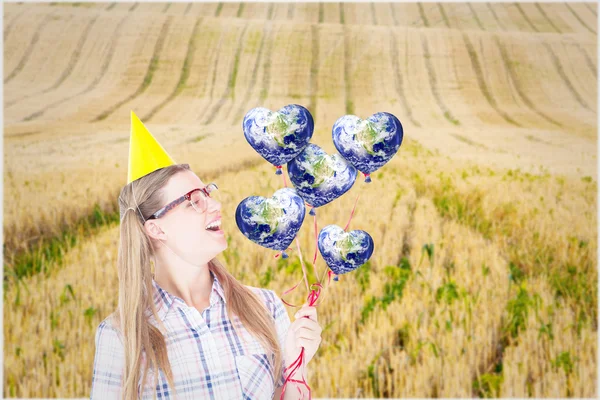 Geeky hipster holding red balloons — Stock Photo, Image
