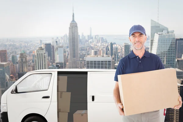 Happy delivery man holding cardboard box — Stock Photo, Image