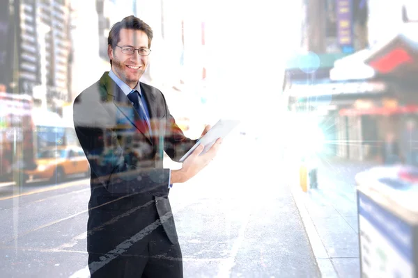 Geschäftsmann schaut während der Benutzung in die Kamera — Stockfoto