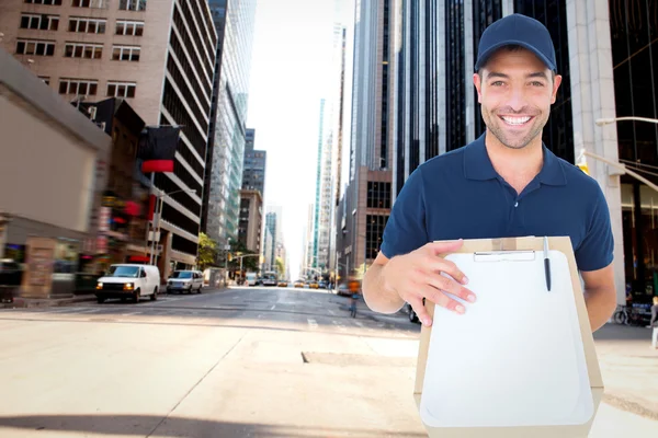 Imagen compuesta de hombre entrega feliz con paquete y portapapeles —  Fotos de Stock