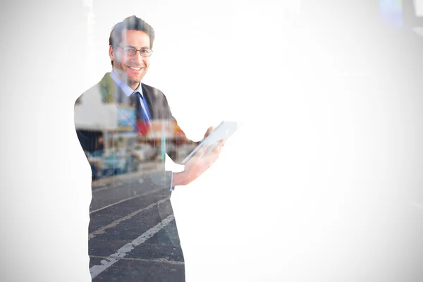 Businessman looking at the camera while using — Stock Photo, Image